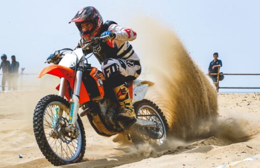 man on sand dunes riding motorcycle